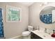 Neutral bathroom featuring a toilet, sink with black countertop, and a round mirror at 1478 Interlaken Pass, Jonesboro, GA 30238