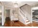 Elegant foyer featuring hardwood floors, white wainscoting, staircase, and decorative accents at 1478 Interlaken Pass, Jonesboro, GA 30238