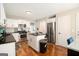 An open kitchen featuring a kitchen island, white cabinets, and stainless steel appliances at 1478 Interlaken Pass, Jonesboro, GA 30238