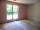 Bedroom featuring a large window letting in natural light, unfinished flooring, and light pink walls at 4382 Highway 42 S, Locust Grove, GA 30248