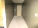 Hallway featuring neutral walls, unfinished flooring, and a white door at the end at 4382 Highway 42 S, Locust Grove, GA 30248