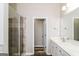 A well-lit bathroom featuring a glass shower, double vanity, and wood-look flooring at 2577 Shropshire Pl, Mcdonough, GA 30253