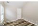 View of the bedroom with wood laminate flooring and natural light streaming through the window at 2577 Shropshire Pl, Mcdonough, GA 30253