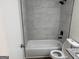 Updated bathroom featuring marble-look shower, updated toilet and tub at 3339 Clevemont Ct, Ellenwood, GA 30294
