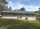 Rear exterior of the home features a lush, grassy lawn, a new roof, and access to a small outdoor patio area at 3339 Clevemont Ct, Ellenwood, GA 30294