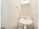 Clean half bath featuring a pedestal sink, mirror, and electrical outlet at 1577 Keystone Dr, Conley, GA 30288