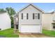 Charming two-story home with gray siding, black shutters, and a two-car garage at 1577 Keystone Dr, Conley, GA 30288