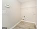 A simple laundry room with ample storage, clean white walls and wood grain flooring at 1577 Keystone Dr, Conley, GA 30288