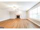 Spacious living room featuring hardwood floors, a brick fireplace, a ceiling fan, and ample natural light at 182 Spivey Glen Dr, Jonesboro, GA 30236
