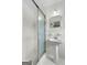 Bright bathroom featuring a glass-enclosed shower and classic pedestal sink at 1226 Pine Knoll, Conyers, GA 30013