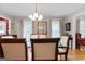 A dining room with hardwood floors, a glass table, floral curtains and a view to the front foyer at 1226 Pine Knoll, Conyers, GA 30013