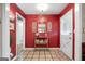 Foyer featuring red accent wall, a white door, and view into adjacent room at 1226 Pine Knoll, Conyers, GA 30013