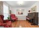 Cozy living room with red armchairs, piano, hardwood floors, and natural light, creating a warm and inviting atmosphere at 1226 Pine Knoll, Conyers, GA 30013