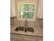 Modern kitchen featuring stainless steel sink, granite countertops, and view of the trees outside the window at 518 Paynes Lake Rd, Carrollton, GA 30116