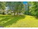 Spacious backyard featuring lush lawn, mature trees, offering a peaceful outdoor retreat at 229 Lafayette St, Locust Grove, GA 30248