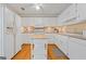 Well-lit kitchen boasting white cabinets, a center island, hardwood flooring, and modern appliances for everyday convenience at 229 Lafayette St, Locust Grove, GA 30248
