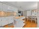 Bright eat-in kitchen featuring white cabinets, an island, and hardwood floors at 229 Lafayette St, Locust Grove, GA 30248
