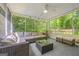 Relaxing screened-in porch featuring cozy seating arrangements, a ceiling fan, and natural views at 229 Lafayette St, Locust Grove, GA 30248