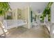 Inviting front porch with a swing, rocking chairs, decorative plants, and a ceiling fan for relaxed outdoor enjoyment at 229 Lafayette St, Locust Grove, GA 30248