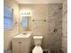 Bright bathroom with white vanity, toilet, and tiled shower at 310 Flagstone Sw Dr, Atlanta, GA 30331