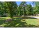 Spacious backyard with mature trees, lush green grass, and a fenced perimeter for privacy and security at 3005 Ryan Rd, Locust Grove, GA 30248