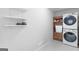 Well-organized laundry room with front loading washer and dryer, shelving and cabinet at 3005 Ryan Rd, Locust Grove, GA 30248