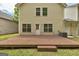 Backyard with a wooden deck and ample green space behind a light yellow townhouse at 737 Shadow Lake Dr, Lithonia, GA 30058