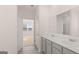 Bathroom featuring double sinks with marble countertops with view of adjacent room at 162 Aster Ave, Locust Grove, GA 30248