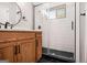 Stylish bathroom features a wooden vanity, round mirror, walk-in shower with black hexagon tile and white subway tile at 1336 Mcclelland Ave, Atlanta, GA 30344