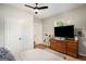 Bright bedroom features a ceiling fan, hardwood floors, closet, and a dresser with a television set at 1336 Mcclelland Ave, Atlanta, GA 30344