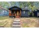 Charming home features a black exterior, wooden porch, and a well-maintained front yard at 1336 Mcclelland Ave, Atlanta, GA 30344