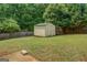 Backyard featuring a storage shed surrounded by a grass and a wood fence at 823 Hennepin Ter, Mcdonough, GA 30253