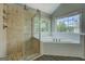 Bathroom featuring a glass-enclosed shower, garden tub, and large windows at 823 Hennepin Ter, Mcdonough, GA 30253