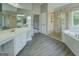 Large bathroom with tub, shower and dual sinks and wood-look floors at 823 Hennepin Ter, Mcdonough, GA 30253