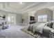 Main bedroom showcasing a king-size bed, accent chair, television, and ensuite bathroom at 823 Hennepin Ter, Mcdonough, GA 30253