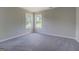 Bright, empty bedroom with neutral walls and carpet, featuring a large window and natural light at 823 Hennepin Ter, Mcdonough, GA 30253