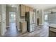Open kitchen with stainless steel refrigerator, granite countertop, and view to other rooms at 823 Hennepin Ter, Mcdonough, GA 30253