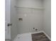 Compact laundry room offers white walls, utility connections, shelf, and tile and laminate flooring at 823 Hennepin Ter, Mcdonough, GA 30253