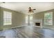 Spacious living room boasts a fireplace, ceiling fan, and large windows for plenty of light at 823 Hennepin Ter, Mcdonough, GA 30253