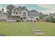 Expansive backyard featuring a stone walkway, patio, screened porch, and lush greenery at 207 Tiverton Trl, Peachtree City, GA 30269