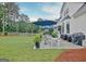 Backyard patio with wicker furniture, blue umbrellas, lush greenery, and views of the surrounding landscape at 207 Tiverton Trl, Peachtree City, GA 30269