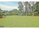Well-manicured backyard with lush green grass and mature trees creates a private and serene outdoor space at 207 Tiverton Trl, Peachtree City, GA 30269