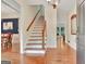 Bright foyer featuring hardwood floors, stairs, and views into the dining and living areas at 207 Tiverton Trl, Peachtree City, GA 30269