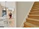 Hallway view of the staircase and a dining area with modern light fixture and a glimpse of the living room at 207 Tiverton Trl, Peachtree City, GA 30269