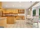 Spacious kitchen featuring ample cabinetry, an island with cooktop, and an adjacent breakfast area with bay window at 207 Tiverton Trl, Peachtree City, GA 30269