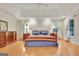 Bright main bedroom featuring tray ceilings, warm lighting, and wood flooring at 207 Tiverton Trl, Peachtree City, GA 30269