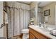 Well-lit bathroom featuring neutral colors, a vanity, decorative shower curtain, and coordinated wall art at 273 Prominent Loop, Mcdonough, GA 30253