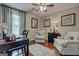 Comfortable sitting area in bedroom featuring hardwood floors, soft armchairs, and natural light from a large window at 273 Prominent Loop, Mcdonough, GA 30253