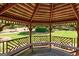 A wooden gazebo with seating and a detailed lattice design with a lovely view of the backyard at 273 Prominent Loop, Mcdonough, GA 30253