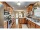 Well-lit kitchen with stainless steel appliances, wooden cabinets, and an island with a sink at 273 Prominent Loop, Mcdonough, GA 30253